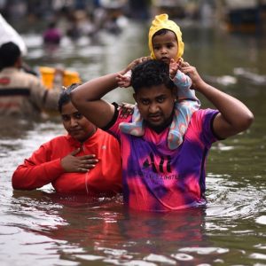 Post cyclone michaung family wades through floods.