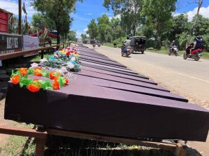 Row of coffins lined up on the side of the road